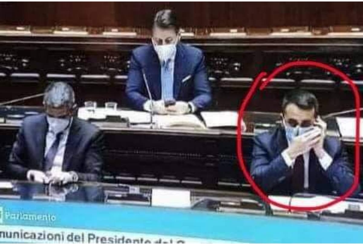 Di maio che si copre la bocca mentre parla a telefono. Con la mascherina.